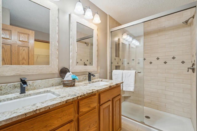 full bathroom with a sink, a textured ceiling, and a shower stall