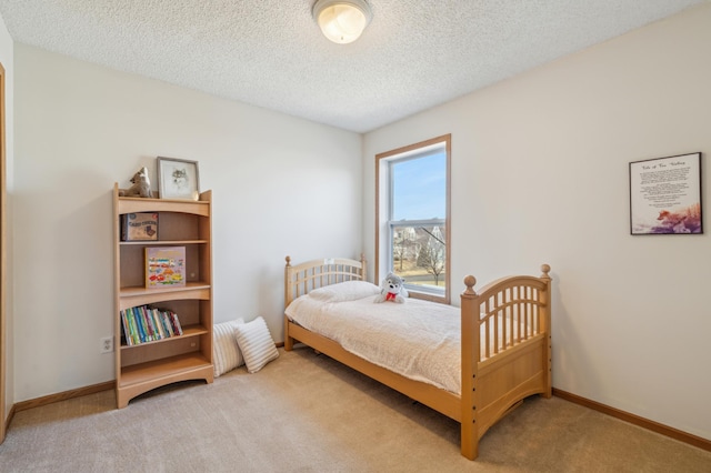 bedroom featuring baseboards, a textured ceiling, and carpet