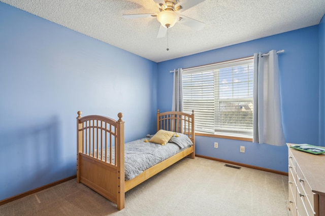 bedroom featuring baseboards, carpet flooring, a textured ceiling, and visible vents