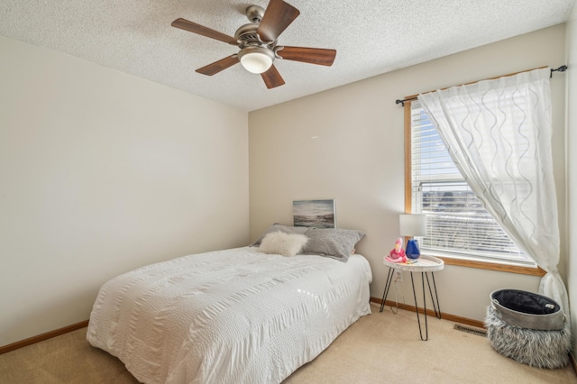 carpeted bedroom with visible vents, a textured ceiling, and baseboards