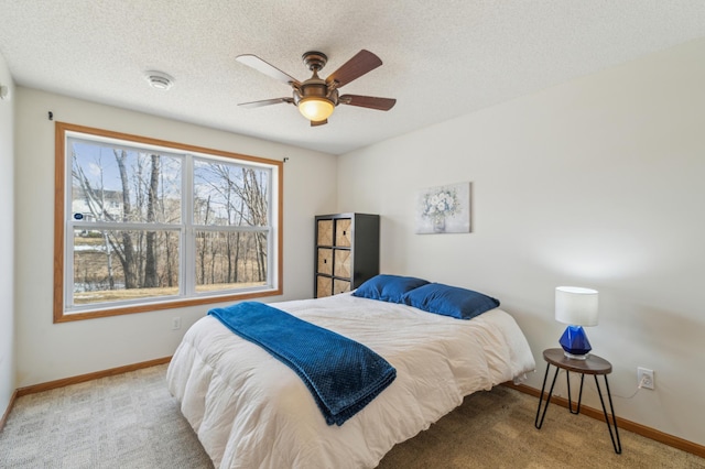 bedroom with ceiling fan, carpet, baseboards, and a textured ceiling