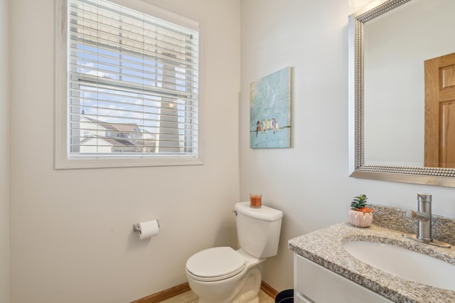 bathroom featuring vanity, toilet, and baseboards