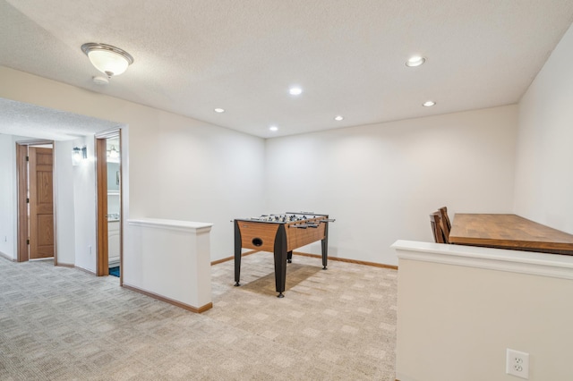 rec room with recessed lighting, light colored carpet, a textured ceiling, and baseboards