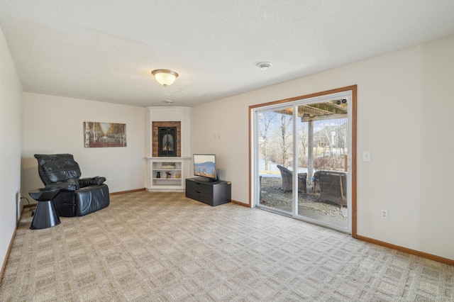 sitting room with carpet, baseboards, and a textured ceiling