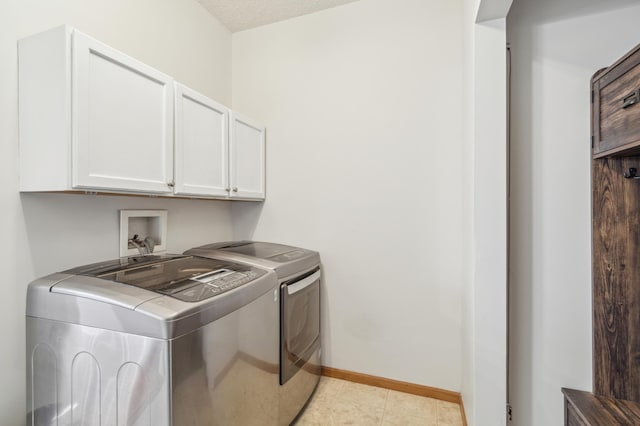 clothes washing area featuring light tile patterned floors, cabinet space, baseboards, and washer and clothes dryer