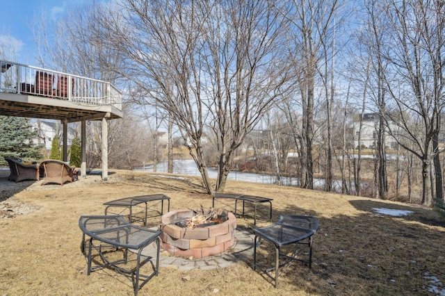 view of yard with a deck and an outdoor fire pit