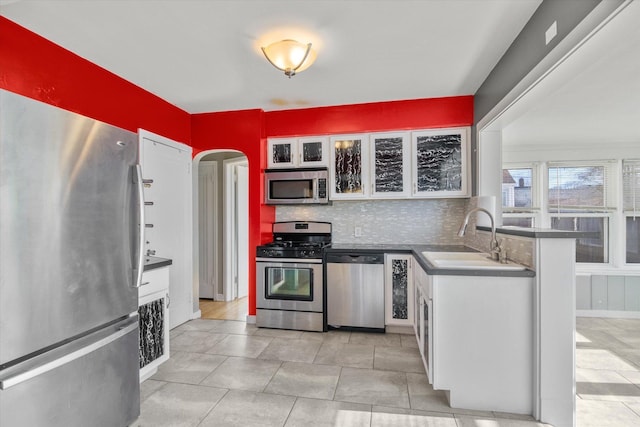 kitchen with backsplash, sink, white cabinets, and appliances with stainless steel finishes