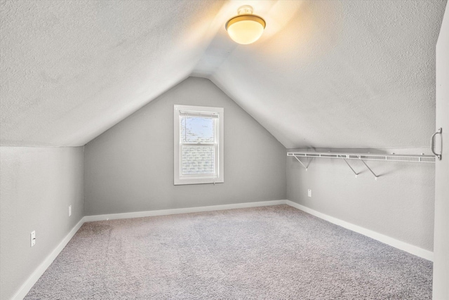 bonus room with a textured ceiling, carpet, and vaulted ceiling