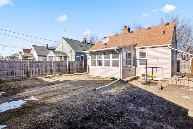 rear view of house featuring a sunroom