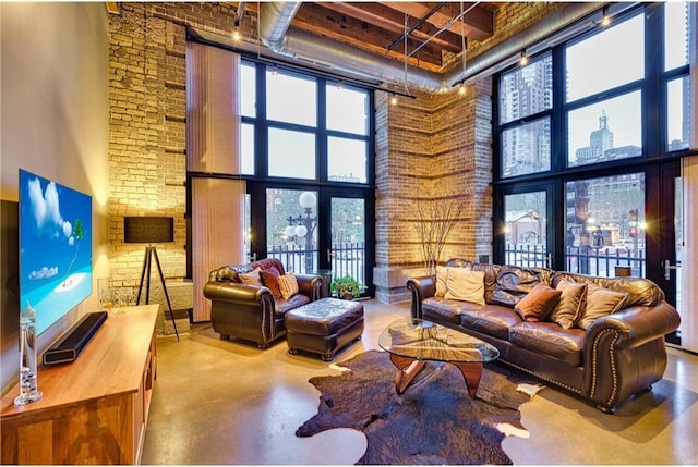 living room with brick wall, a towering ceiling, and concrete flooring