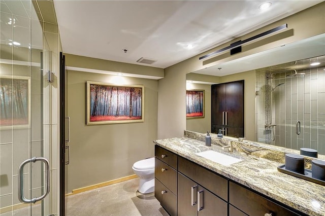 bathroom with toilet, a shower with shower door, and vanity