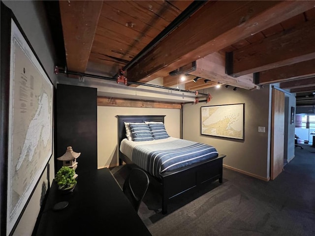 bedroom featuring beam ceiling, wood ceiling, dark carpet, and rail lighting