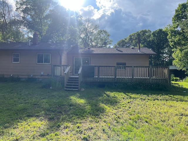 back of property featuring a lawn and a deck