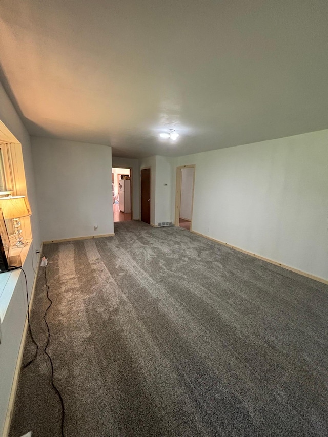 unfurnished living room featuring dark colored carpet