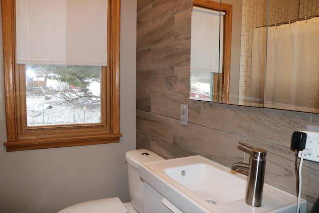 bathroom with toilet, sink, and walk in shower