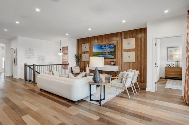 living room featuring light hardwood / wood-style floors and wooden walls