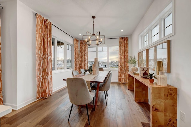 dining room with hardwood / wood-style flooring and an inviting chandelier