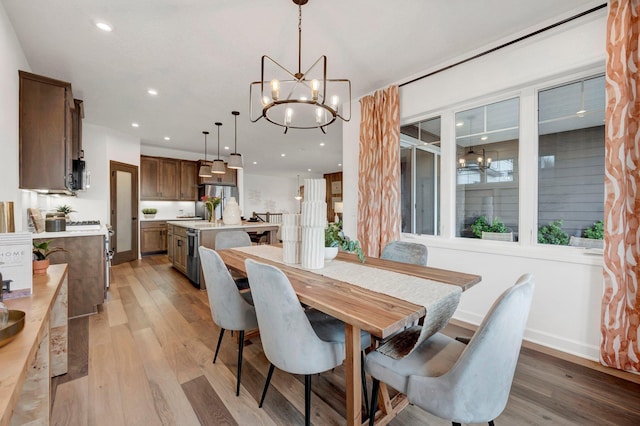 dining space featuring an inviting chandelier and light hardwood / wood-style flooring