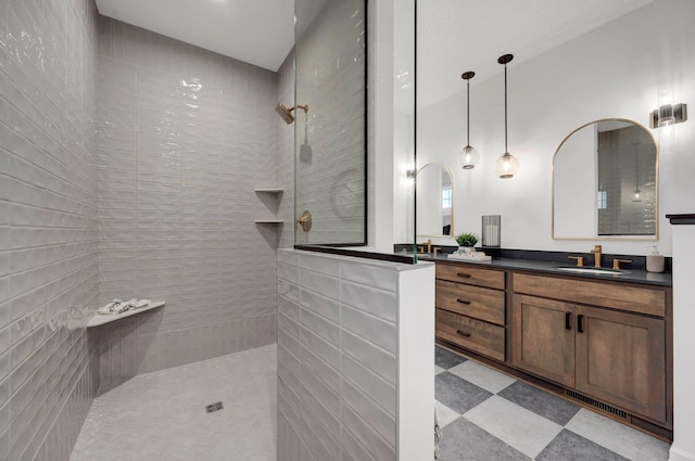 bathroom with vanity and a tile shower