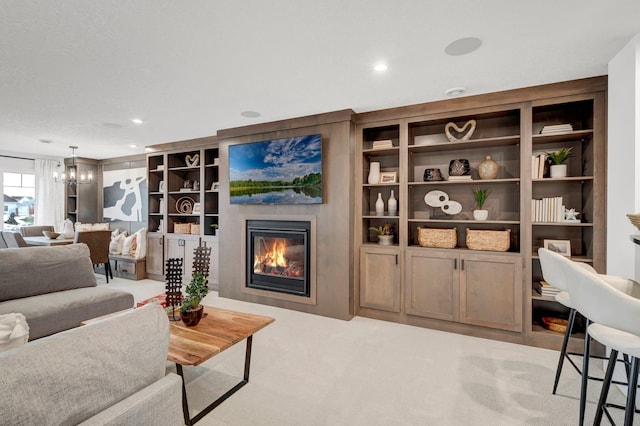 carpeted living room featuring built in features and an inviting chandelier