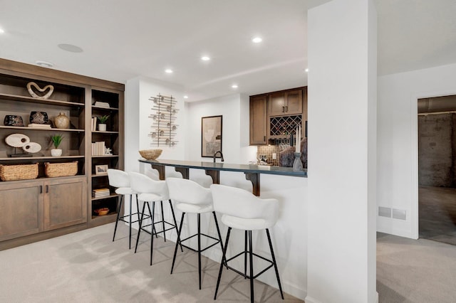 bar with light carpet, built in shelves, and backsplash