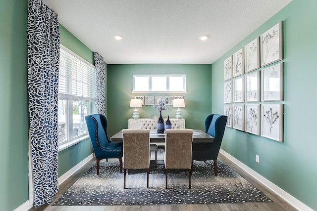 dining area with hardwood / wood-style floors and a textured ceiling