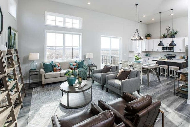 living room featuring a towering ceiling, a wealth of natural light, and a chandelier