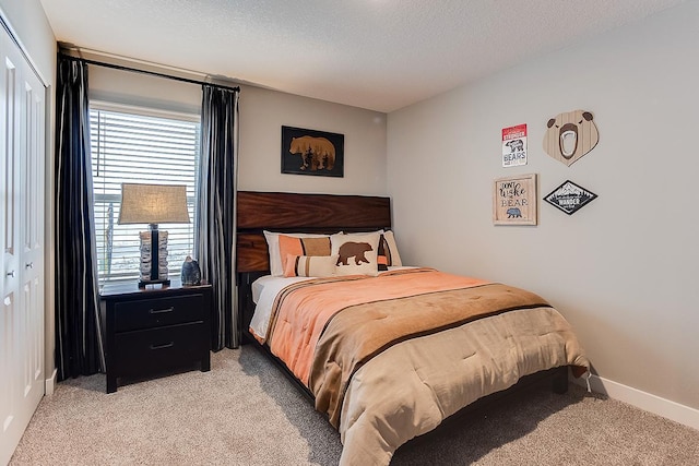 bedroom with baseboards, light carpet, a textured ceiling, and multiple windows