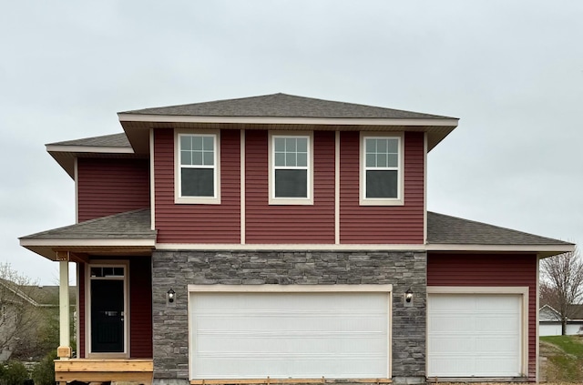 view of front of property with a garage, a shingled roof, and stone siding