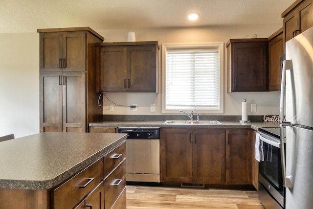 kitchen featuring sink, a center island, light hardwood / wood-style flooring, and appliances with stainless steel finishes