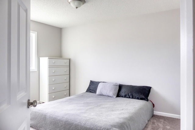 carpeted bedroom with a textured ceiling