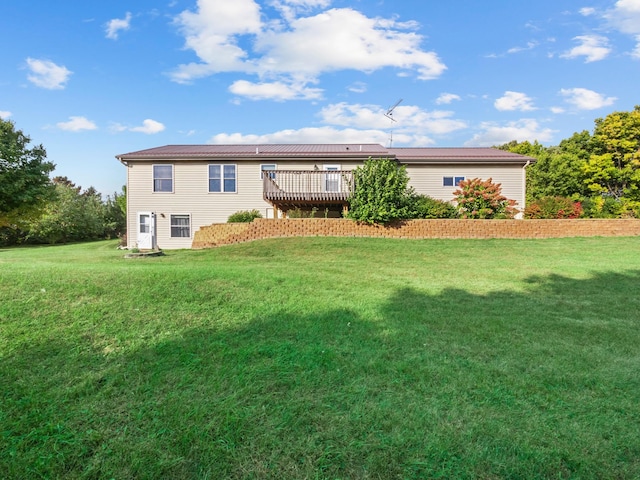 back of house featuring a lawn and a wooden deck