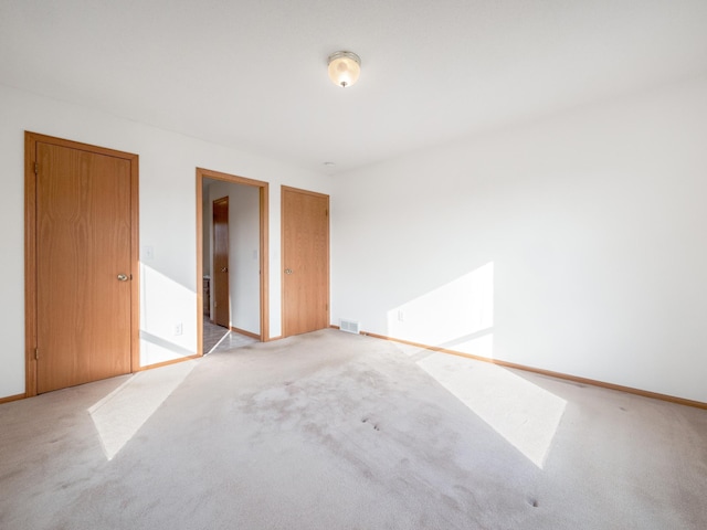 unfurnished bedroom featuring light carpet