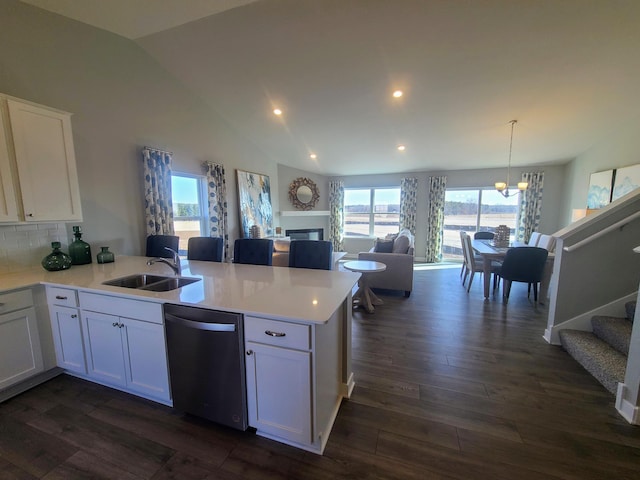 kitchen with dishwasher, backsplash, kitchen peninsula, sink, and white cabinetry