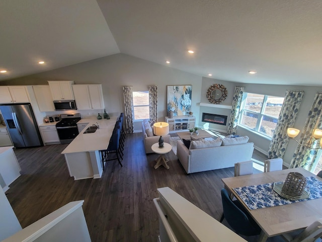 living room with dark hardwood / wood-style flooring, lofted ceiling, and sink