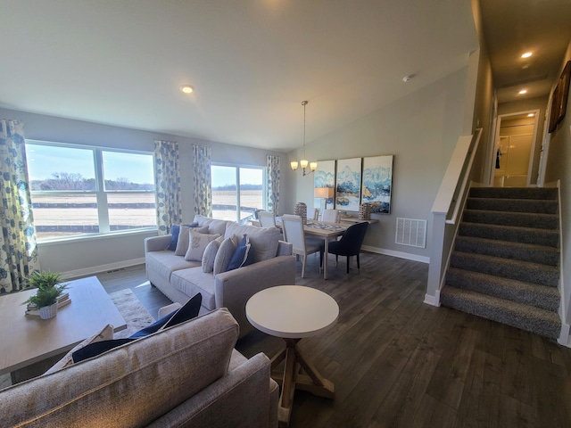 living room featuring a chandelier, a water view, dark wood-type flooring, and lofted ceiling