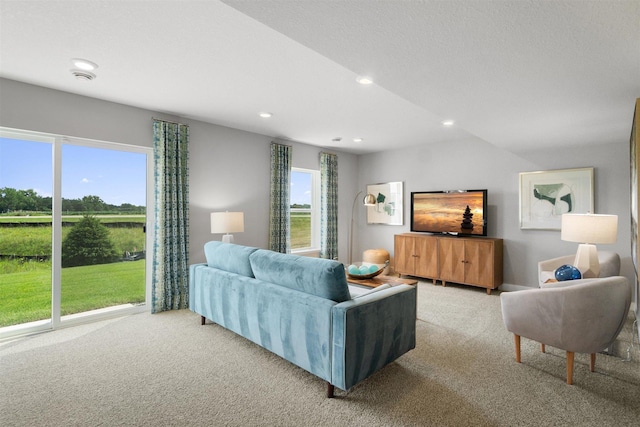 living room featuring a healthy amount of sunlight, light carpet, and vaulted ceiling