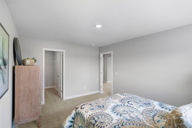 bedroom with light carpet, a spacious closet, and a closet