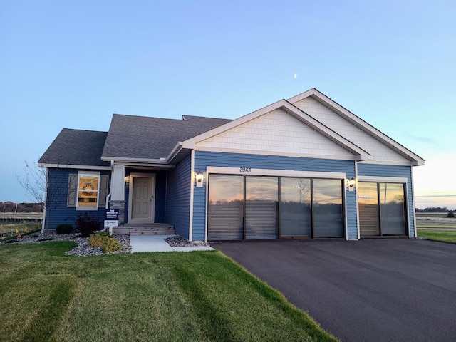 view of front of house with a garage and a lawn