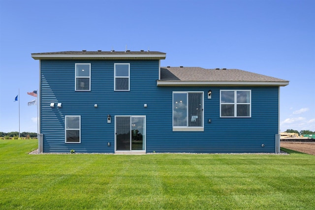 rear view of house featuring a yard