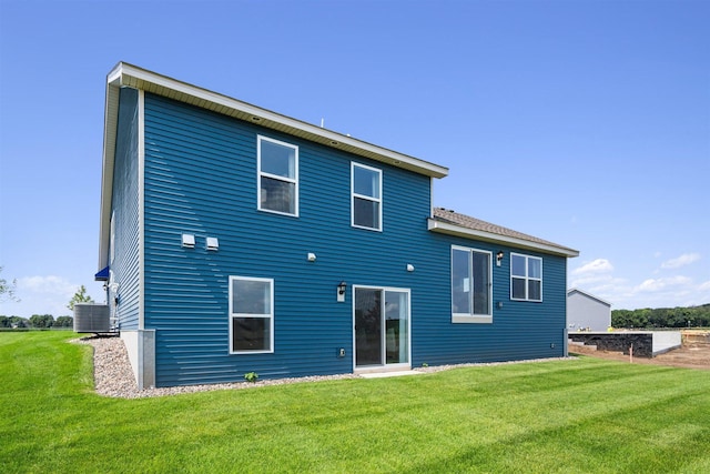 back of property featuring a lawn and central air condition unit