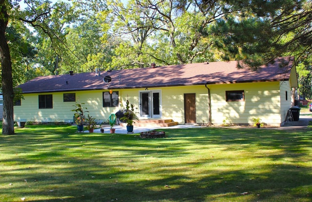 rear view of property featuring a lawn