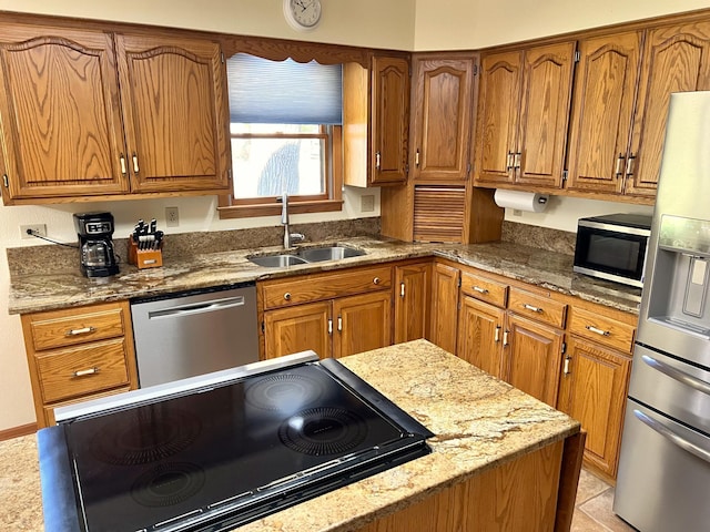 kitchen with light stone countertops, sink, light tile patterned flooring, and appliances with stainless steel finishes