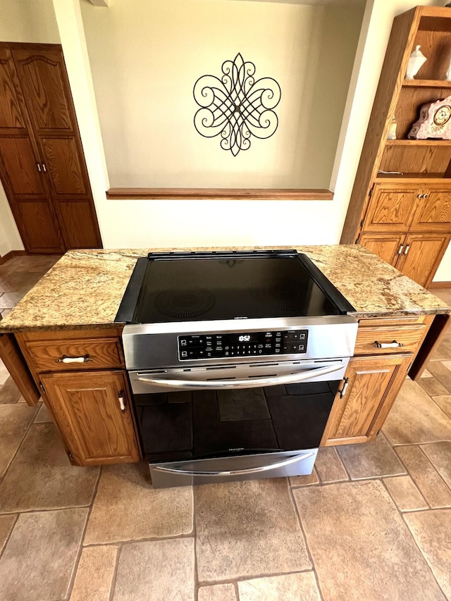 kitchen featuring light stone countertops and stainless steel range oven