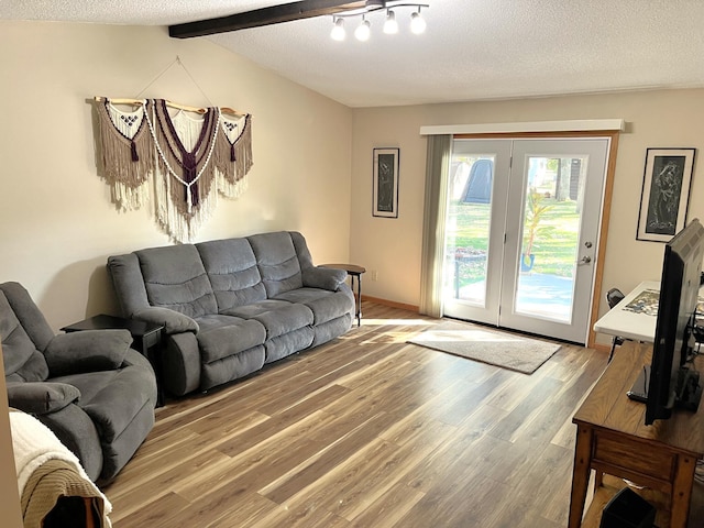 living room featuring hardwood / wood-style floors, a textured ceiling, and lofted ceiling with beams