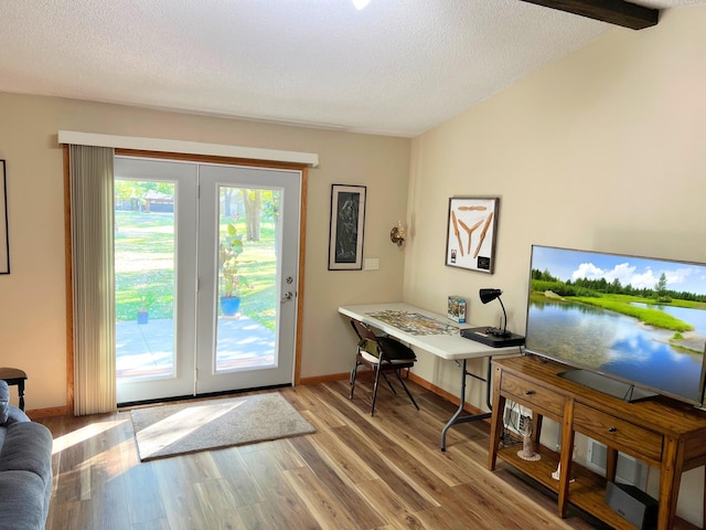 office area featuring lofted ceiling with beams, a textured ceiling, and light hardwood / wood-style floors