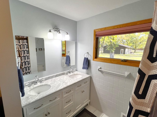 bathroom with vanity, tile patterned floors, and tile walls