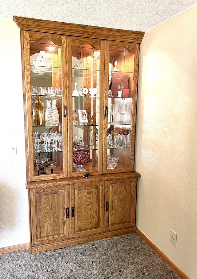 bar with carpet floors and a textured ceiling