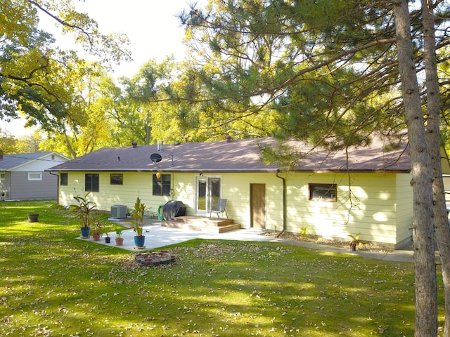 back of property with central air condition unit, a patio area, and a yard