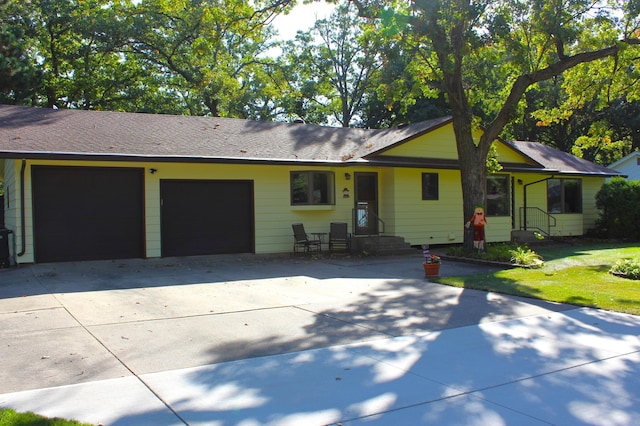 ranch-style home featuring a front lawn and a garage